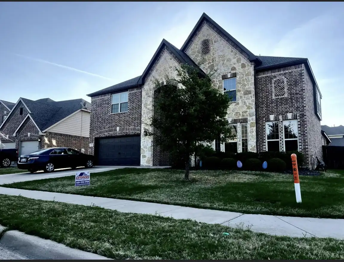 Pro Exteriors inspector documenting storm hail damage on a residential roof, close-up on dented shingle