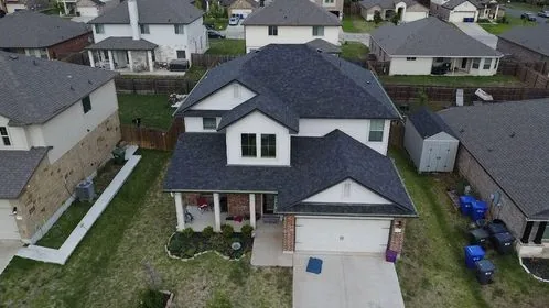Close-up of properly installed architectural asphalt shingles on a residential roof, showing exposure pattern and ridge cap detail